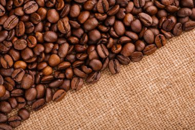 kahve çekirdekleri çuval bezi arka plan üzerinde. kavrulmuş kahvenin beyaz arka planda izole. Kavrulmuş kahve çekirdekleri arka plan kapatın. Kahve çekirdekleri kazık kopya alanı metin için beyaz zemin üzerine üstten