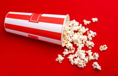 Kırmızı ve beyaz karton kutu içinde patlamış mısır. Patlamış mısır sınır üzerinde beyaz izole. Film. Fast food. Mısır