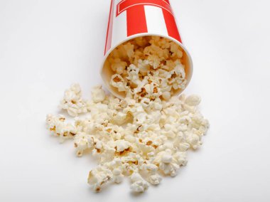 Kırmızı ve beyaz karton kutu içinde patlamış mısır. Patlamış mısır sınır üzerinde beyaz izole. Film. Fast food. Mısır