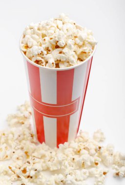 Kırmızı ve beyaz karton kutu içinde patlamış mısır. Patlamış mısır sınır üzerinde beyaz izole. Film. Fast food. Mısır