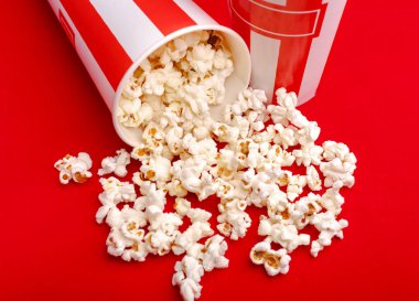 Kırmızı ve beyaz karton kutu içinde patlamış mısır. Patlamış mısır sınır üzerinde beyaz izole. Film. Fast food. Mısır