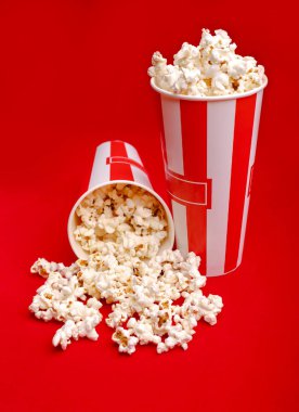 Kırmızı ve beyaz karton kutu içinde patlamış mısır. Patlamış mısır sınır üzerinde beyaz izole. Film. Fast food. Mısır