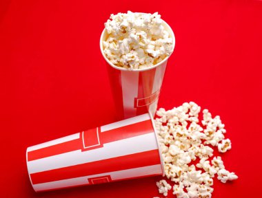 Kırmızı ve beyaz karton kutu içinde patlamış mısır. Patlamış mısır sınır üzerinde beyaz izole. Film. Fast food. Mısır