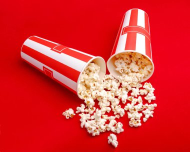 Kırmızı ve beyaz karton kutu içinde patlamış mısır. Patlamış mısır sınır üzerinde beyaz izole. Film. Fast food. Mısır