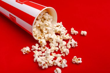 Kırmızı ve beyaz karton kutu içinde patlamış mısır. Patlamış mısır sınır üzerinde beyaz izole. Film. Fast food. Mısır