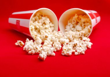 Kırmızı ve beyaz karton kutu içinde patlamış mısır. Patlamış mısır sınır üzerinde beyaz izole. Film. Fast food. Mısır