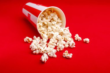 Kırmızı ve beyaz karton kutu içinde patlamış mısır. Patlamış mısır sınır üzerinde beyaz izole. Film. Fast food. Mısır