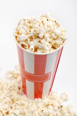 Kırmızı ve beyaz karton kutu içinde patlamış mısır. Patlamış mısır sınır üzerinde beyaz izole. Film. Fast food. Mısır