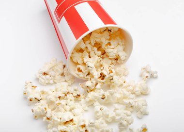 Kırmızı ve beyaz karton kutu içinde patlamış mısır. Patlamış mısır sınır üzerinde beyaz izole. Film. Fast food. Mısır