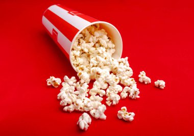 Kırmızı ve beyaz karton kutu içinde patlamış mısır. Patlamış mısır sınır üzerinde beyaz izole. Film. Fast food. Mısır