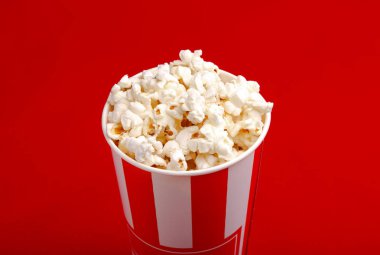 Kırmızı ve beyaz karton kutu içinde patlamış mısır. Patlamış mısır sınır üzerinde beyaz izole. Film. Fast food. Mısır