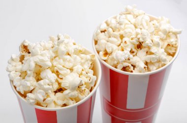 Kırmızı ve beyaz karton kutu içinde patlamış mısır. Patlamış mısır sınır üzerinde beyaz izole. Film. Fast food. Mısır