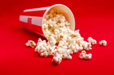 Kırmızı ve beyaz karton kutu içinde patlamış mısır. Patlamış mısır sınır üzerinde beyaz izole. Film. Fast food. Mısır