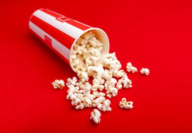 Kırmızı ve beyaz karton kutu içinde patlamış mısır. Patlamış mısır sınır üzerinde beyaz izole. Film. Fast food. Mısır