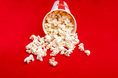 Kırmızı ve beyaz karton kutu içinde patlamış mısır. Patlamış mısır sınır üzerinde beyaz izole. Film. Fast food. Mısır