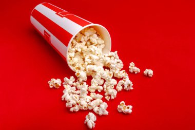 Kırmızı ve beyaz karton kutu içinde patlamış mısır. Patlamış mısır sınır üzerinde beyaz izole. Film. Fast food. Mısır