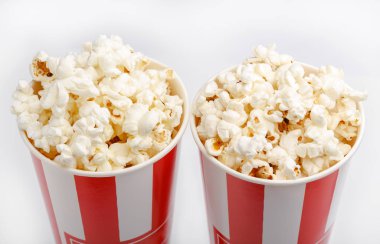 Kırmızı ve beyaz karton kutu içinde patlamış mısır. Patlamış mısır sınır üzerinde beyaz izole. Film. Fast food. Mısır