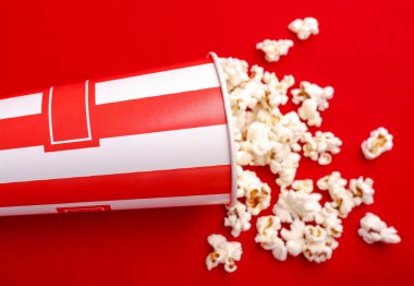 Kırmızı ve beyaz karton kutu içinde patlamış mısır. Patlamış mısır sınır üzerinde beyaz izole. Film. Fast food. Mısır