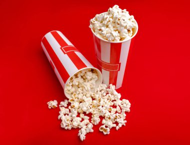 Kırmızı ve beyaz karton kutu içinde patlamış mısır. Patlamış mısır sınır üzerinde beyaz izole. Film. Fast food. Mısır