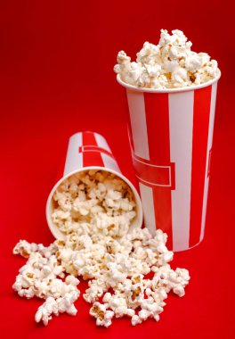 Kırmızı ve beyaz karton kutu içinde patlamış mısır. Patlamış mısır sınır üzerinde beyaz izole. Film. Fast food. Mısır