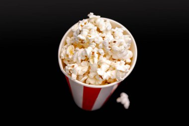 Kırmızı ve beyaz karton kutu içinde patlamış mısır. Patlamış mısır sınır üzerinde beyaz izole. Film. Fast food. Mısır