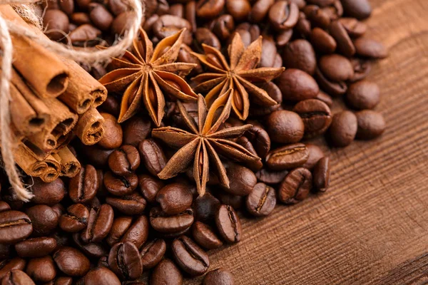Kahve çekirdekleri ve tarçın çuval bezi bir arka plan üzerinde. Kavrulmuş kahve çekirdekleri arka plan kapatın. Üst metin kopyalama yeri olan kahve çekirdekleri kazık. Baharat. Baharat. Tarçın. Badian. Kahve evi.