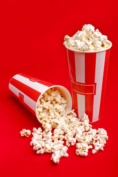 Kırmızı ve beyaz karton kutu içinde patlamış mısır. Patlamış mısır sınır üzerinde beyaz izole. Film. Fast food. Mısır