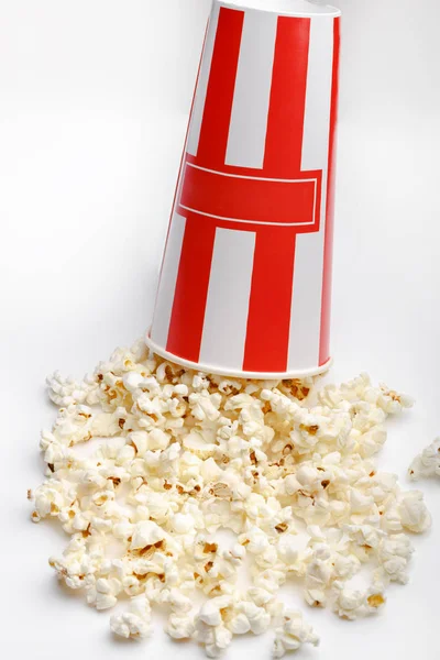 Kırmızı ve beyaz karton kutu içinde patlamış mısır. Patlamış mısır sınır üzerinde beyaz izole. Film. Fast food. Mısır