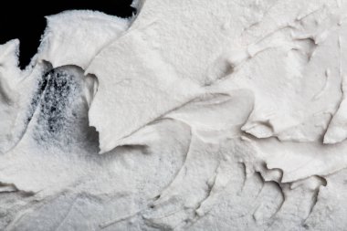 Yapısal Alçı beyaz siyah bir arka plan. Beyaz krema. boya karalama. Hamuru