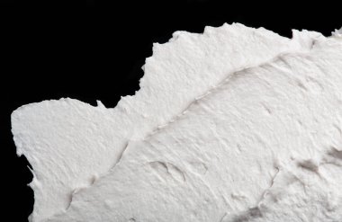 Yapısal Alçı beyaz siyah bir arka plan. Beyaz krema. boya karalama. Hamuru