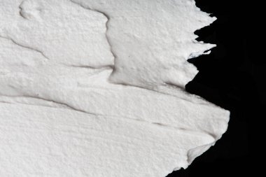 Yapısal Alçı beyaz siyah bir arka plan. Beyaz krema. boya karalama. Hamuru