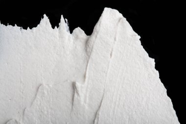 Yapısal Alçı beyaz siyah bir arka plan. Beyaz krema. boya karalama. Hamuru