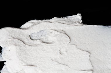 Yapısal Alçı beyaz siyah bir arka plan. Beyaz krema. boya karalama. Hamuru