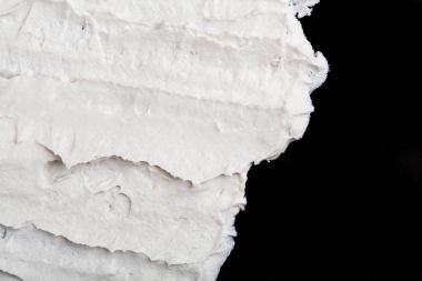 Yapısal Alçı beyaz siyah bir arka plan. Beyaz krema. boya karalama. Hamuru