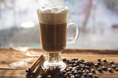 Cappuccino ve kahve çekirdekleri, tarçın. arka plan kavrulmuş kahve çekirdekleri yakın çekim. Kahve çekirdekleri ile metin için yer. Baharat. Baharat. Tarçın. Badian. Kahve evi. Latte. Kapuçino.