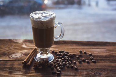 Cappuccino ve kahve çekirdekleri, tarçın. arka plan kavrulmuş kahve çekirdekleri yakın çekim. Kahve çekirdekleri ile metin için yer. Baharat. Baharat. Tarçın. Badian. Kahve evi. Latte. Kapuçino.