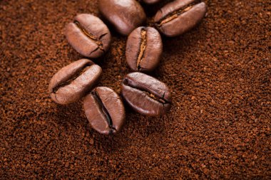 kavrulmuş kahvenin beyaz arka planda izole. Kavrulmuş kahve çekirdekleri arka plan kapatın. Kahve çekirdekleri çekilmiş kahve ile kopya alanı metin için arka plan üzerinde kazık. Günaydın.