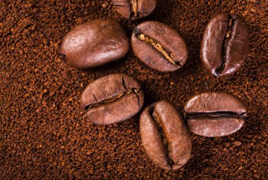 kavrulmuş kahvenin beyaz arka planda izole. Kavrulmuş kahve çekirdekleri arka plan kapatın. Kahve çekirdekleri çekilmiş kahve ile kopya alanı metin için arka plan üzerinde kazık. Günaydın.