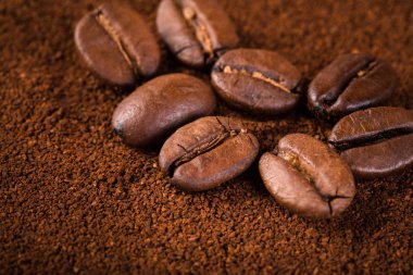 kavrulmuş kahvenin beyaz arka planda izole. Kavrulmuş kahve çekirdekleri arka plan kapatın. Kahve çekirdekleri çekilmiş kahve ile kopya alanı metin için arka plan üzerinde kazık. Günaydın.