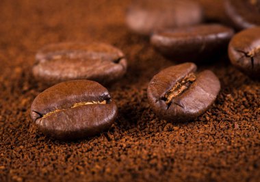 kavrulmuş kahvenin beyaz arka planda izole. Kavrulmuş kahve çekirdekleri arka plan kapatın. Kahve çekirdekleri çekilmiş kahve ile kopya alanı metin için arka plan üzerinde kazık. Günaydın.