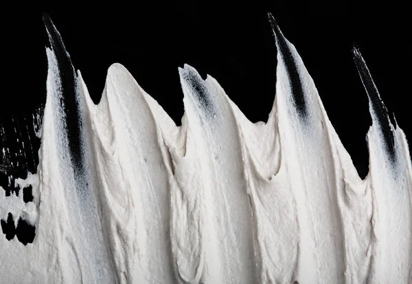 Yapısal Alçı beyaz siyah bir arka plan. Beyaz krema. boya karalama. Hamuru