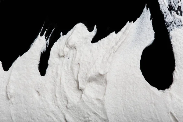 Structural plaster white on a black background. White Cream. paint smear. Plasticine