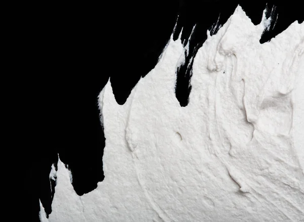 Structural plaster white on a black background. White Cream. paint smear. Plasticine