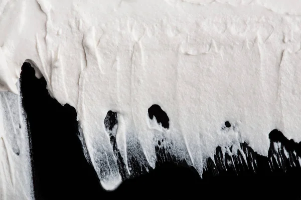 Yapısal Alçı beyaz siyah bir arka plan. Beyaz krema. boya karalama. Hamuru