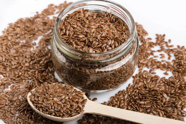 Beyaz arka plan üzerinde izole keten tohumu kapatın. Kase kahverengi keten tohumu ya da keten tohumu dolu. Tahıllar. Vitaminler. Sağlıklı gıda.