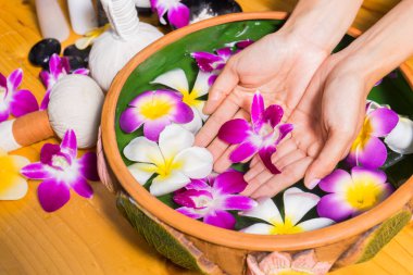 Aroma spa su ahşap masa üzerinde bir kase ile kadın el