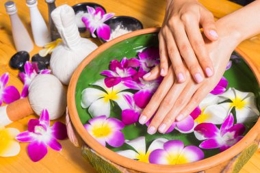 Aroma spa su ahşap masa üzerinde bir kase ile kadın el