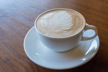 Üstten Görünüm el adamın bir fincan sıcak kahve eski ahşap masa üzerinde tutun