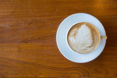 Üstten Görünüm el adamın bir fincan sıcak kahve eski ahşap masa üzerinde tutun