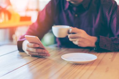 Onun akıllı okunurken gülümseyen genç Asyalı yakışıklı iş adamı